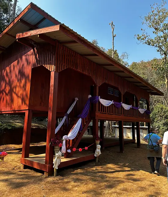 A newly built rural schoolhouse on stilts, decorated for its opening day